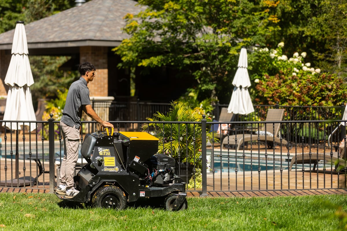 lawn care technician core aerating a lawn