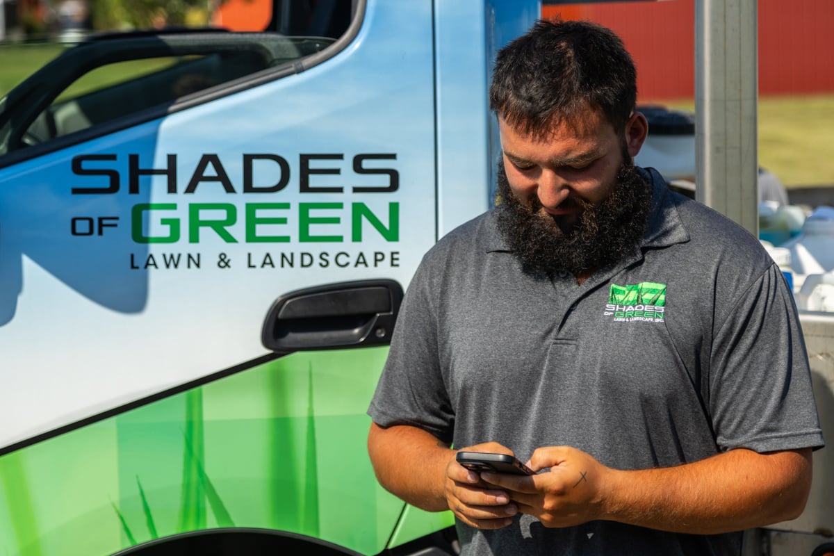 lawn care technician giving client notes on provided services