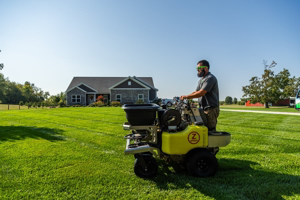 lawn care technician applying a fertilizer treatment