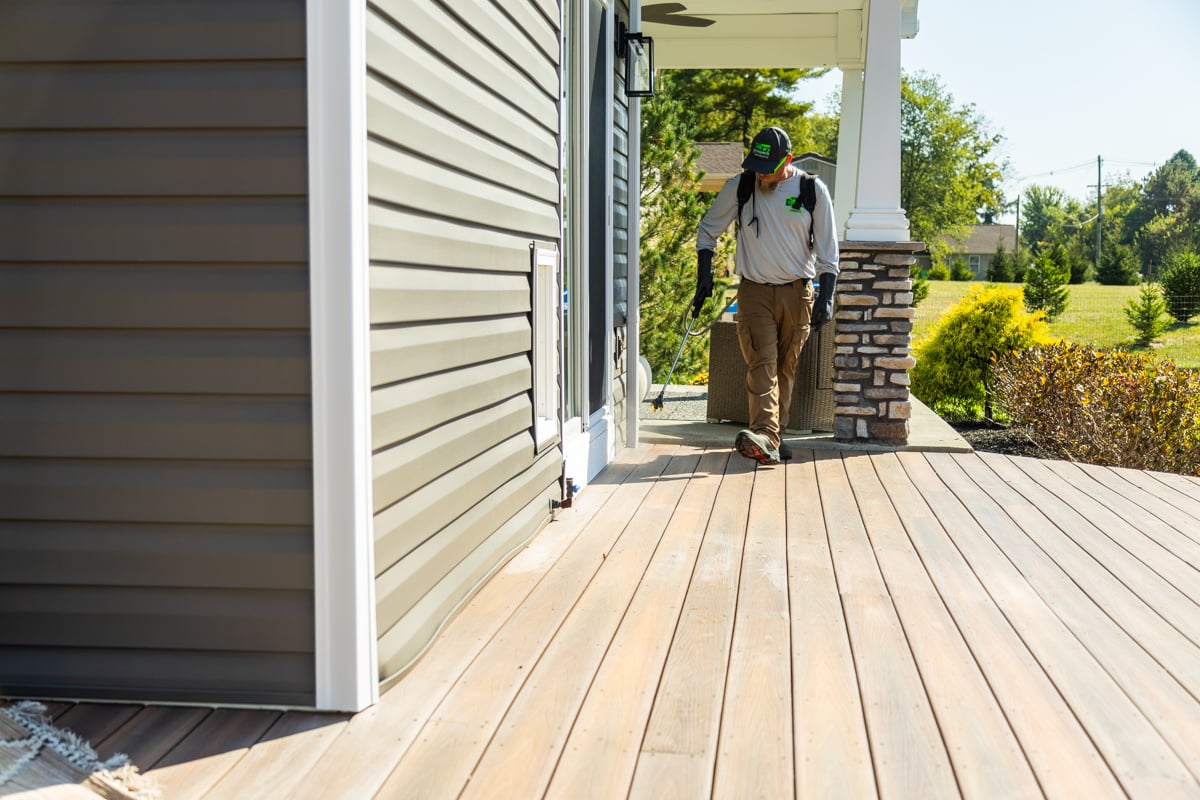 spraying the foundation of a home with pest control products