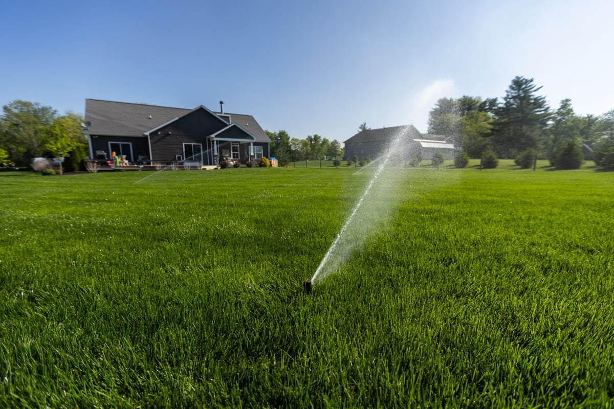 sprinklers running in a healthy green lawn