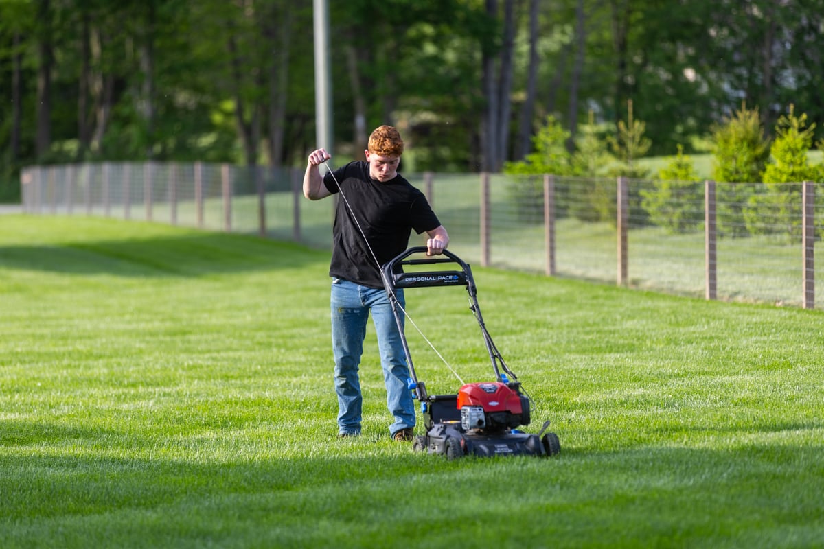 starting up a lawn mower to cut the grass to the right height in Indiana